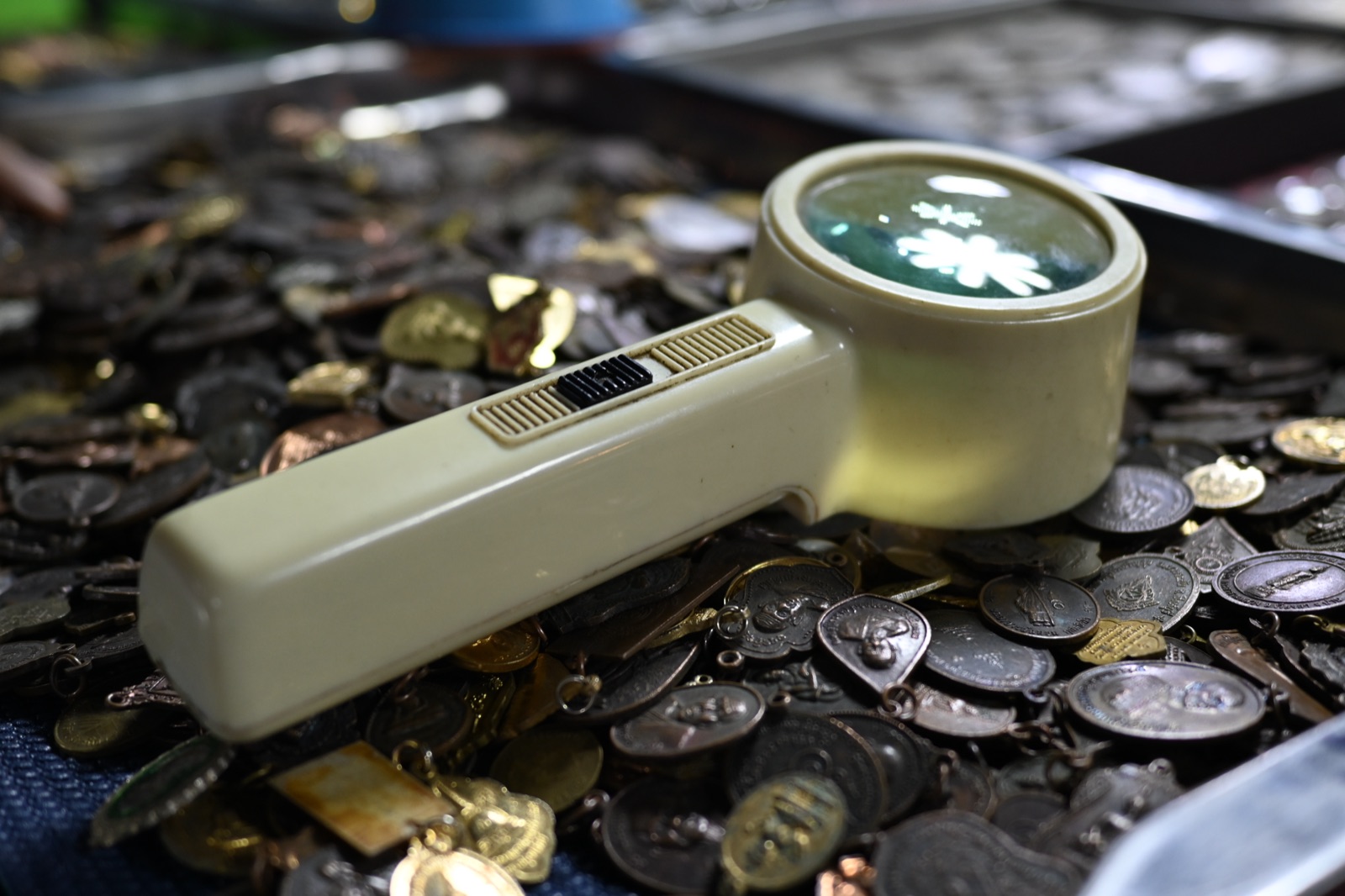 A magnifying loupe resting on a pile of coins