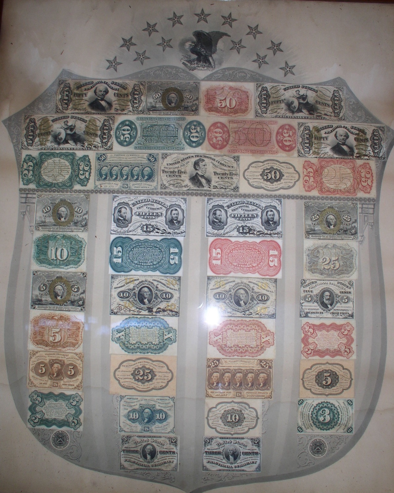 A nineteenth-century shield of United States fractional currency notes under glass